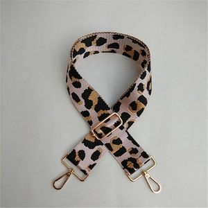Close-up of leopard print bag strap with golden lobster clasps and adjustable buckle