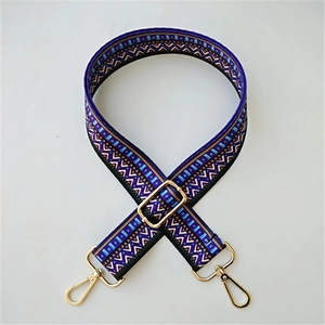 Close-up of geometric ethnic woven strap with golden zinc alloy lobster clasps and buckles