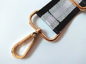 Macro shot of durable black and white striped strap with luxury golden metal clasp