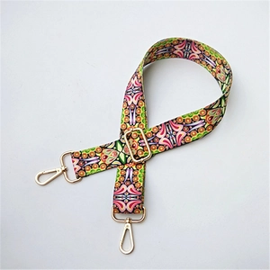 Close-up of geometric ethnic pattern wide shoulder strap with gold metal buckles