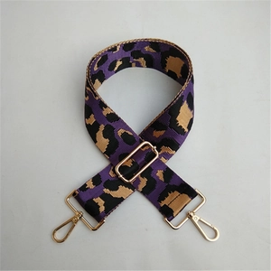 Close-up of adjustable purple leopard print bag strap with polished gold metal hardware