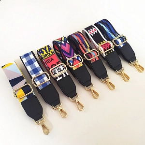 Set of seven colorful ethnic style woven bag straps with gold metal hooks on white background