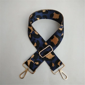 Detail of adjustable blue leopard print bag strap with golden metal swivel hooks