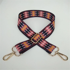 Detailed view of adjustable ethnic geometric pattern shoulder strap with gold metal hooks