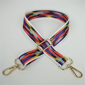 Close-up of ethnic style wide guitar strap with colorful patterns and gold metal hardware