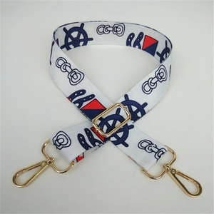 Close-up of nautical patterned wide canvas strap with golden metal lobster clasps and buckles