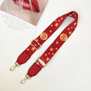 Adjustable wide red shoulder strap with gold star patterns and metallic lobster clasps