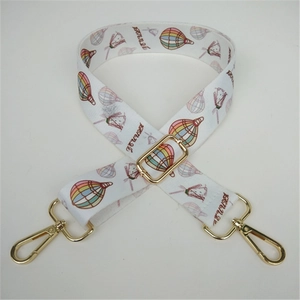 Detail of wide adjustable white strap with colorful hot air balloon patterns and gold hooks