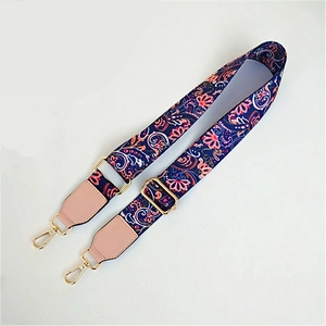 Close-up of adjustable ethnic paisley shoulder strap with pink faux leather and gold hardware