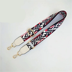 Close-up of geometric ethnic woven bag strap with golden hardware and leather ends