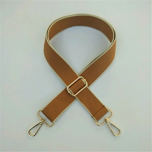 Detail view of adjustable brown canvas strap with golden swivel snap hooks for bags