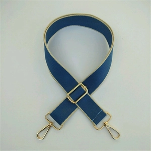 Detail of adjustable dark blue nylon strap with beige edges and gold swivel lobster clasps