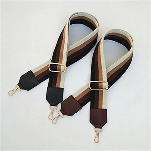 Detail of adjustable thickened wide striped bag straps with gold metal hooks and buckles