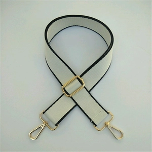 Close-up of beige woven replacement bag strap with black edges and gold metal hardware