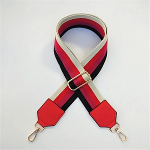Detailed view of colorful striped thick fabric bag strap with gold metal lobster clasps