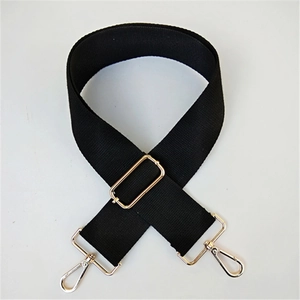 Detail of adjustable black canvas bag strap with shiny gold metal lobster clasps