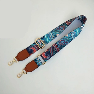 Detailed view of adjustable ethnic paisley strap with leather ends and gold metal hooks
