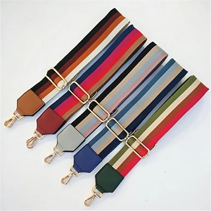 Detail of colorful striped fabric bag straps with gold metal hooks and adjustable buckles