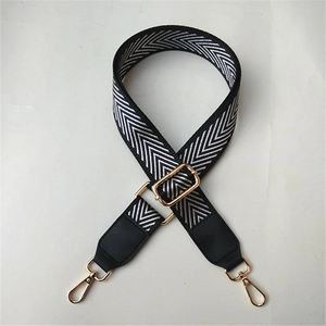 Close-up of adjustable chevron woven bag strap with golden metal hooks and leather detail