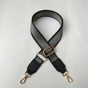Close-up of adjustable wide shoulder strap with black and gold geometric V-pattern