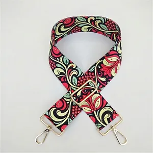 Detail of adjustable bag strap with vine pattern and golden swivel metal hooks