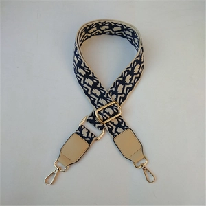 Detail of adjustable oblique jacquard wide shoulder strap with gold metal hooks