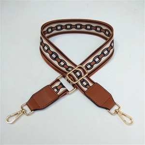 Detail of adjustable wide woven strap with chain pattern and gold metal lobster clasps
