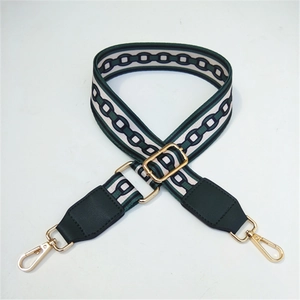 Close-up of woven geometric crossbody strap with green leather ends and gold metal hooks