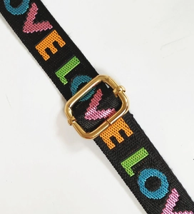 Detail of adjustable black strap with colorful LOVE embroidery and gold buckle