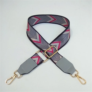 Macro detail of adjustable V-pattern woven strap with grey leather ends and gold metal clips
