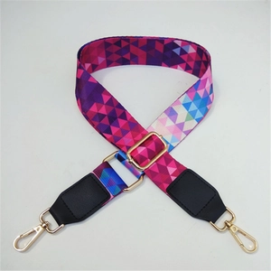 Detail of colorful geometric woven bag strap with golden hooks and black leather ends