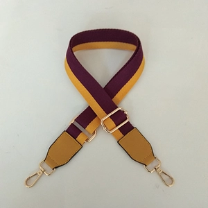 Detail of purple and yellow striped woven shoulder strap with gold metal lobster clasps