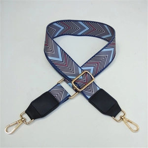 Close-up of geometric V-pattern wide woven bag strap with golden metal swivel hooks