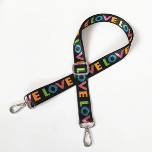Close-up of adjustable nylon strap with colorful LOVE text and silver lobster clips