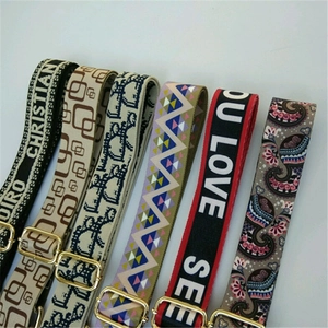 Close-up of adjustable wide canvas bag straps with colorful ethnic patterns and gold buckles