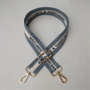 Detail of adjustable blue and white cotton shoulder strap with golden metal lobster clasps
