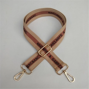 Macro view of wide adjustable cotton shoulder strap with gold metal hardware and stripes
