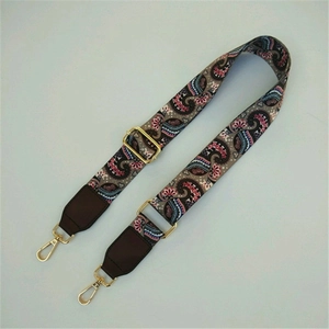 Detail of adjustable paisley embroidered bag strap with golden swivel metal hooks