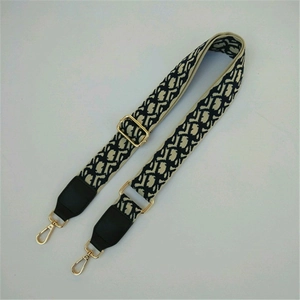 Detail of adjustable wide bag strap featuring black and white jacquard floral embroidery