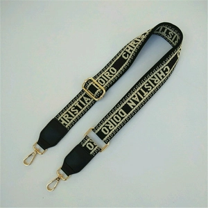 Detail of adjustable floral jacquard bag strap with golden metal lobster clasps
