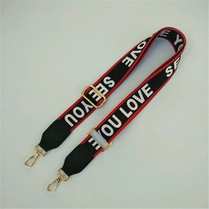 Detail of adjustable patterned shoulder strap with gold hooks and street style text