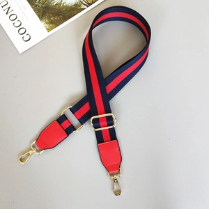 Detail of adjustable red and blue striped woven shoulder strap with gold metal hooks