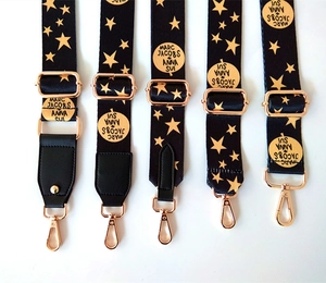 Détail de bandoulières ajustables à motif d'étoiles avec crochets et logos imprimés