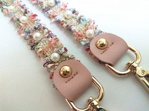 Elegant woven pearl handbag strap with pink leather trim and golden metal hooks