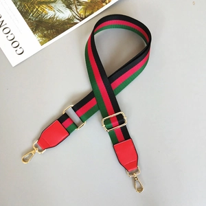 Detail of adjustable green and red striped canvas bag strap with gold lobster clasps
