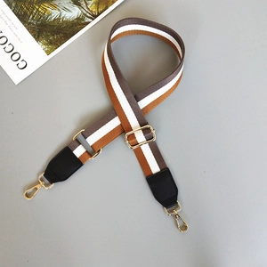 Close-up of adjustable striped canvas strap with golden lobster clasps and black leather trim