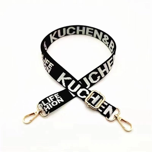 Adjustable black woven bag strap with white KUCHEN lettering and gold lobster clips