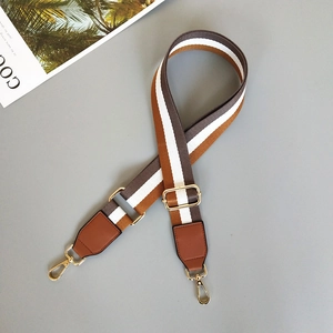 Close-up of adjustable striped woven strap with leather ends and gold metal hooks