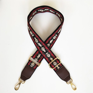 Close-up of wide jacquard bag strap with ethnic horse patterns and gold hardware