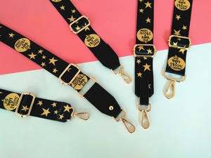 Vue détaillée des bandoulières larges ajustables avec motifs étoiles et crochets dorés